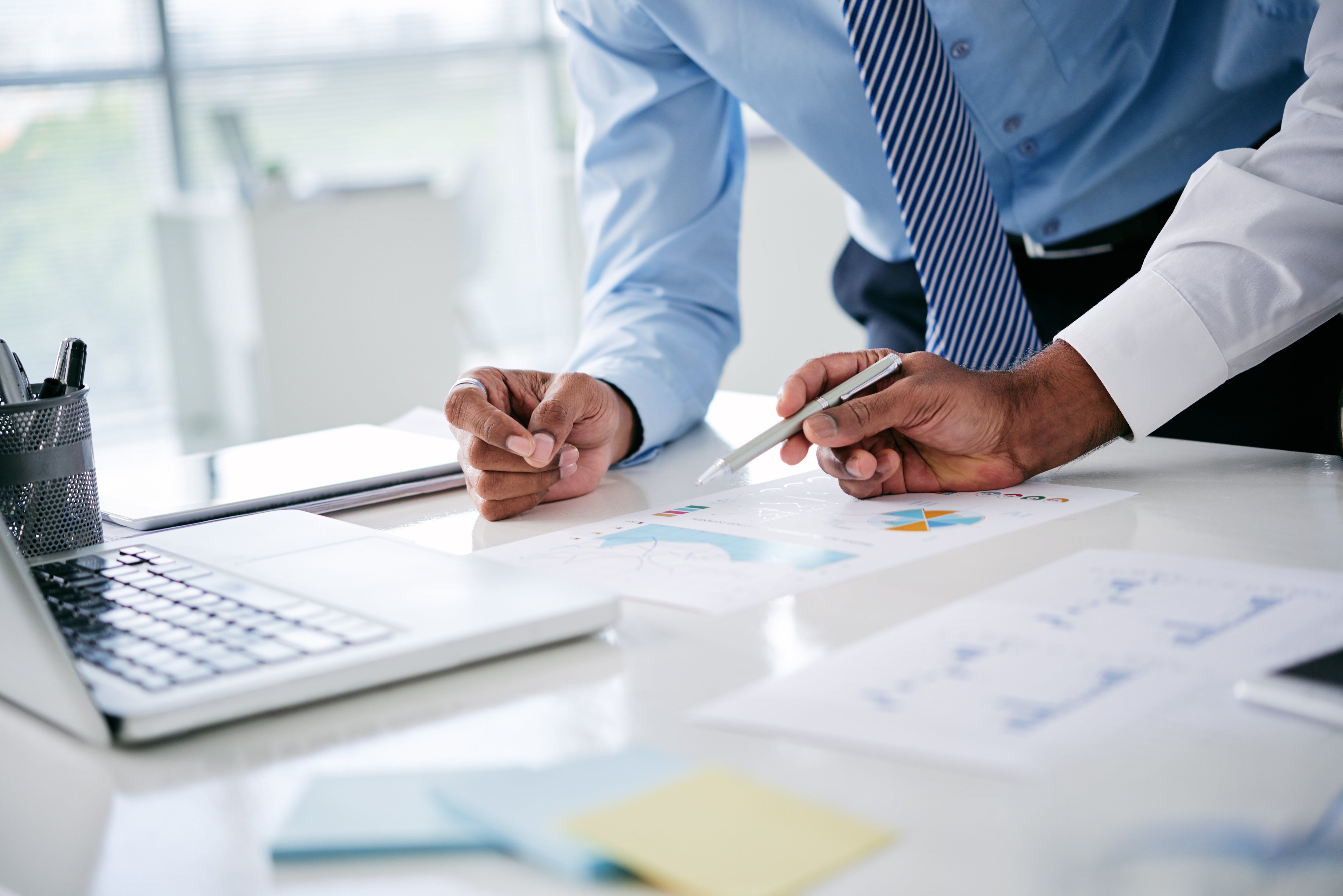 Hands of business people analyzing charts and graphs